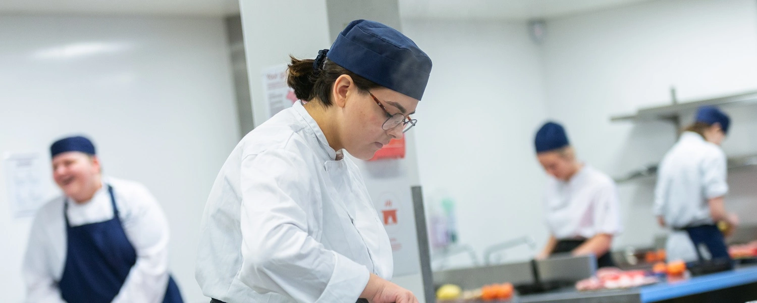 Hospitality student prepares a dish